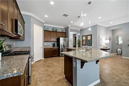 kitchen featuring stone counters, sink, a breakfast bar area, a kitchen island with sink, and stainless steel appliances