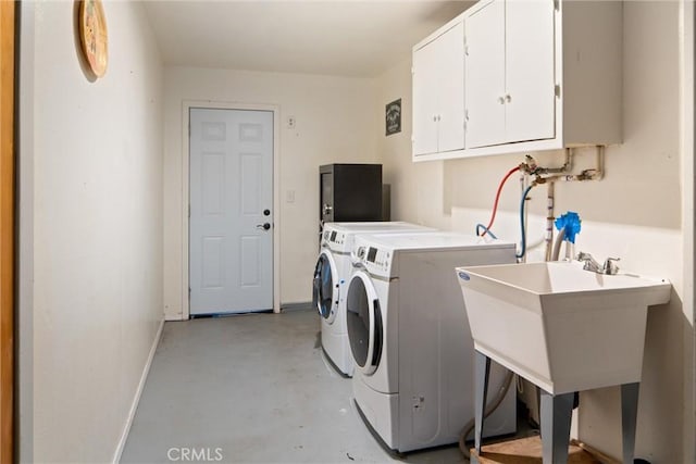 washroom with cabinets, sink, and independent washer and dryer