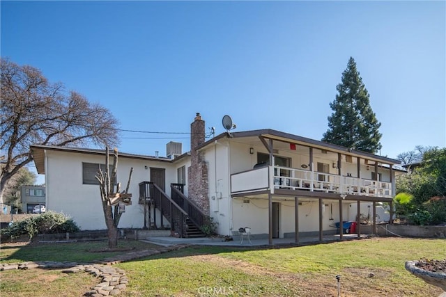 back of property with a yard and a patio area