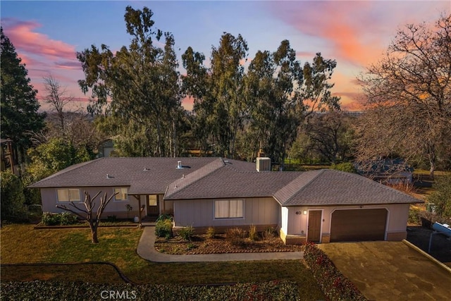 single story home featuring a garage and a yard