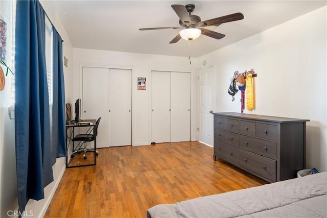 bedroom featuring multiple closets, ceiling fan, and light hardwood / wood-style floors