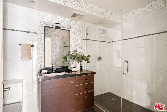 bathroom with a shower with door and vanity