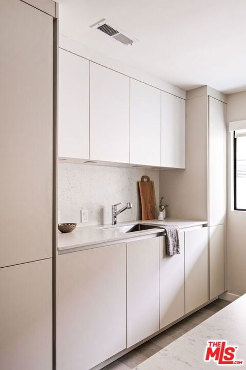 kitchen featuring white cabinetry and sink