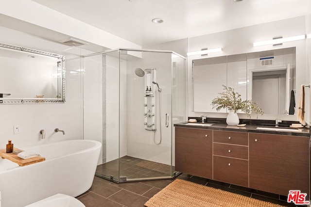 bathroom with tile patterned flooring, vanity, and separate shower and tub