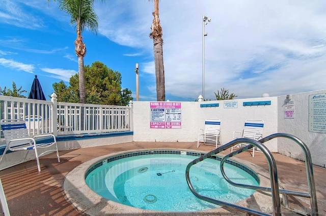 view of pool with a hot tub