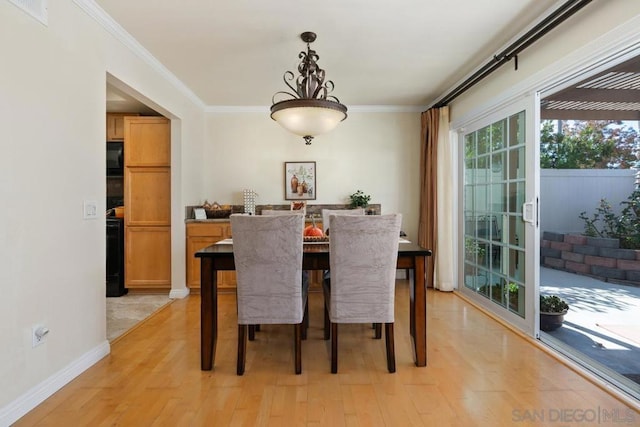 dining area featuring ornamental molding and light hardwood / wood-style floors