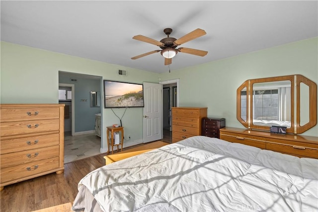 bedroom featuring hardwood / wood-style flooring, ceiling fan, and connected bathroom