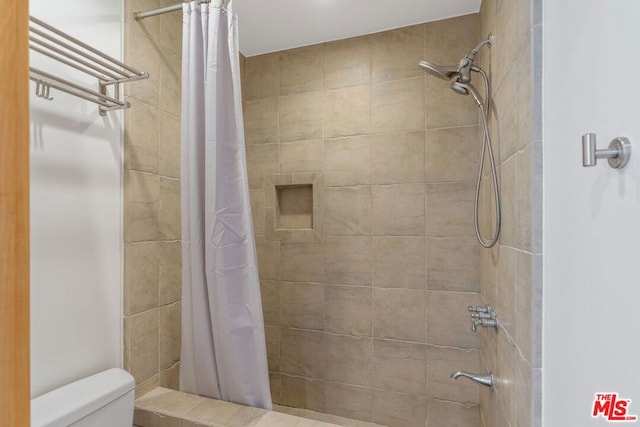 bathroom featuring a shower with curtain and toilet