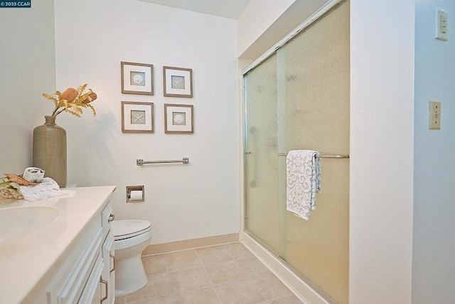 bathroom with tile patterned floors, vanity, toilet, and a shower with door