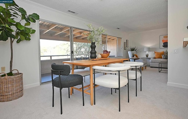 dining area featuring light colored carpet and a textured ceiling