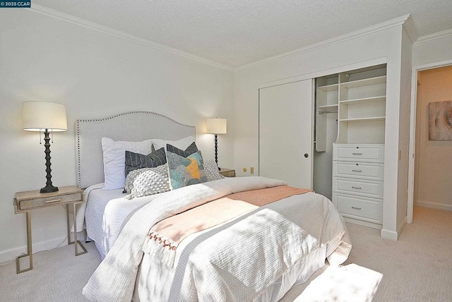 carpeted bedroom with crown molding, a textured ceiling, and a closet