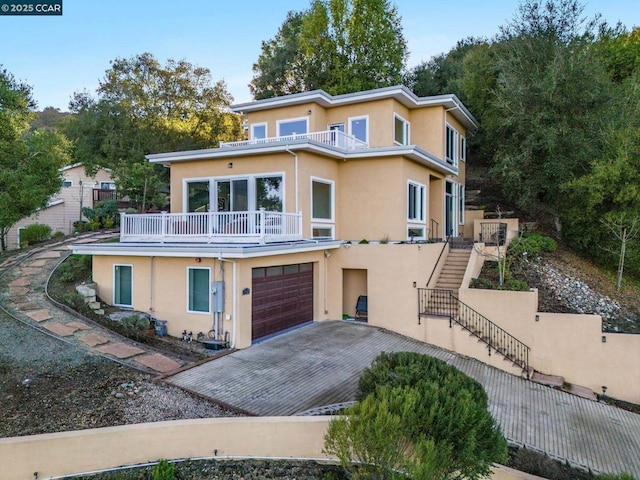 view of front facade featuring a balcony and a garage