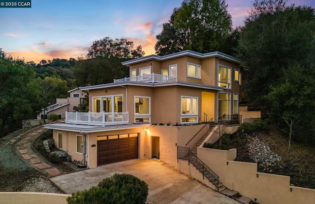 view of front of property featuring a balcony and a garage