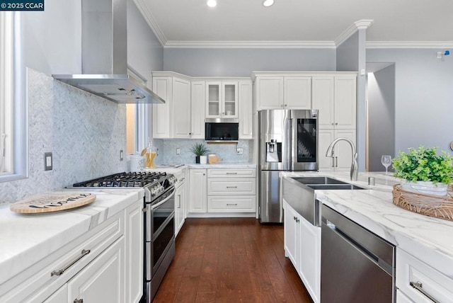 kitchen with wall chimney range hood, sink, white cabinetry, stainless steel appliances, and light stone countertops