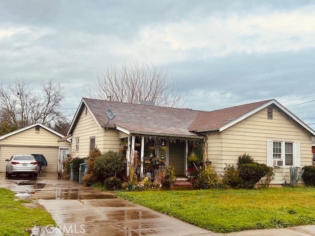 view of front of house with a garage, an outdoor structure, and a front yard