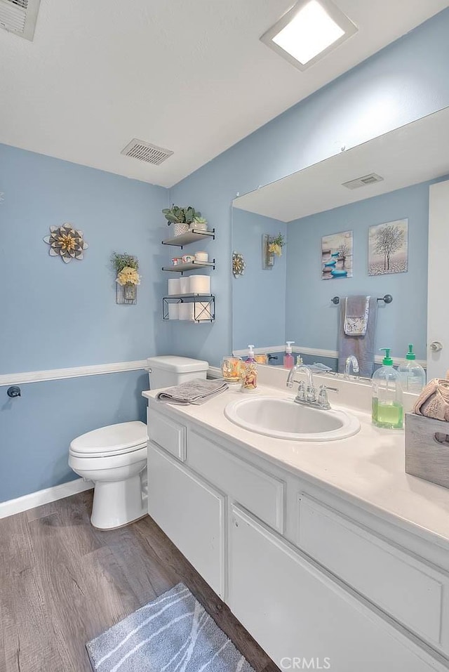 bathroom featuring vanity, hardwood / wood-style floors, and toilet