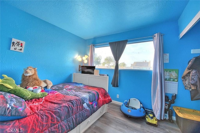 bedroom featuring wood-type flooring and a textured ceiling