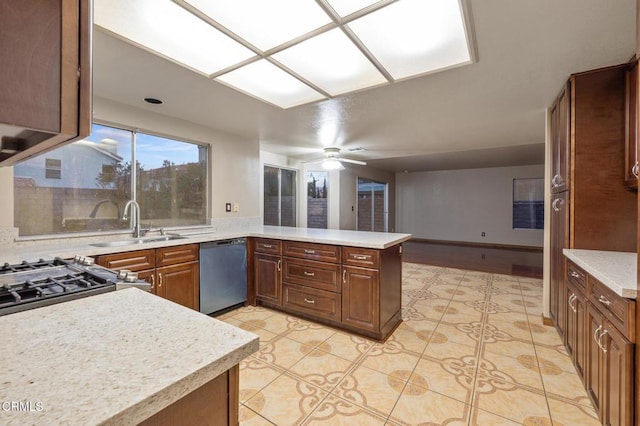 kitchen with sink, light tile patterned floors, ceiling fan, kitchen peninsula, and stainless steel appliances