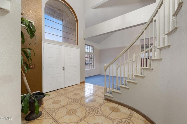 entryway featuring light tile patterned floors and a towering ceiling