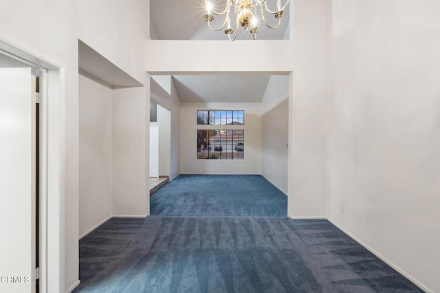 interior space with an inviting chandelier, dark carpet, and lofted ceiling