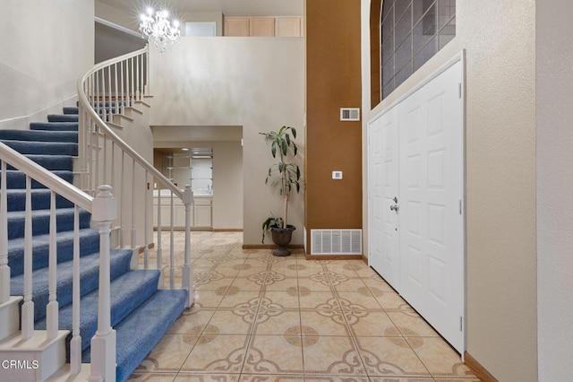 entrance foyer featuring a high ceiling, light tile patterned flooring, and a chandelier