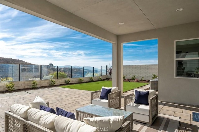 view of patio with a mountain view, an outdoor hangout area, and a fenced backyard