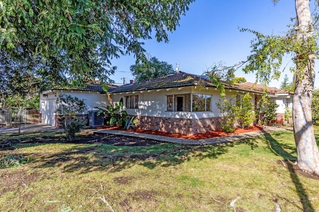 exterior space featuring a garage, a yard, and central AC unit