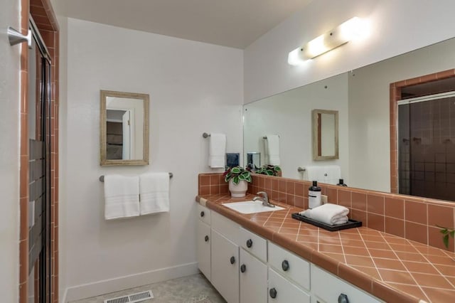 bathroom featuring vanity, backsplash, and a shower with shower door