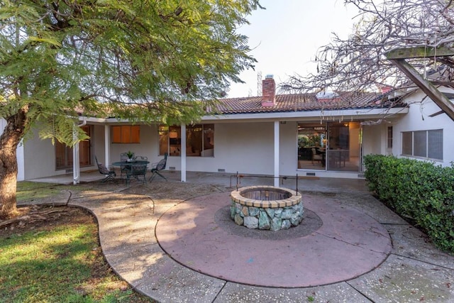 rear view of house with a patio and an outdoor fire pit