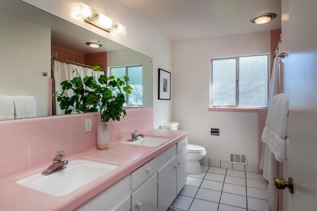 bathroom with tasteful backsplash, vanity, tile patterned flooring, and toilet