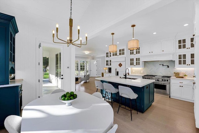 dining room featuring sink, a chandelier, and light hardwood / wood-style flooring