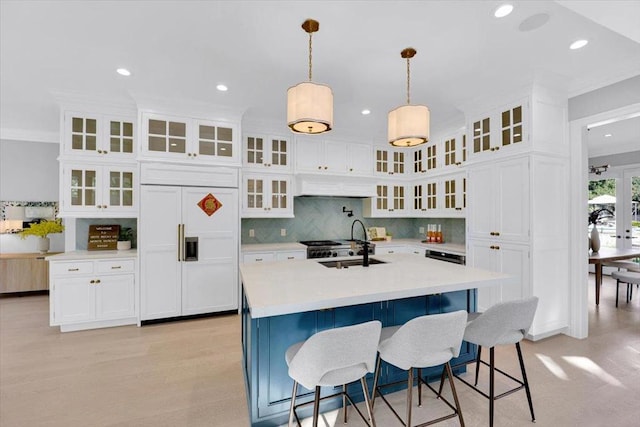 kitchen with white cabinetry, hanging light fixtures, paneled built in fridge, and sink