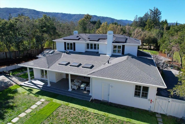 back of house featuring a mountain view, a yard, and a patio area