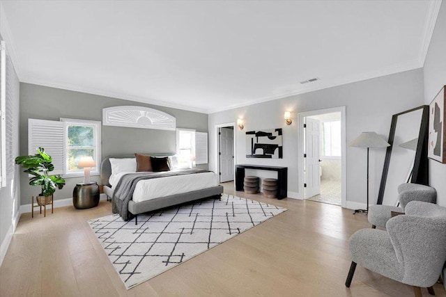 bedroom featuring ornamental molding and light hardwood / wood-style floors