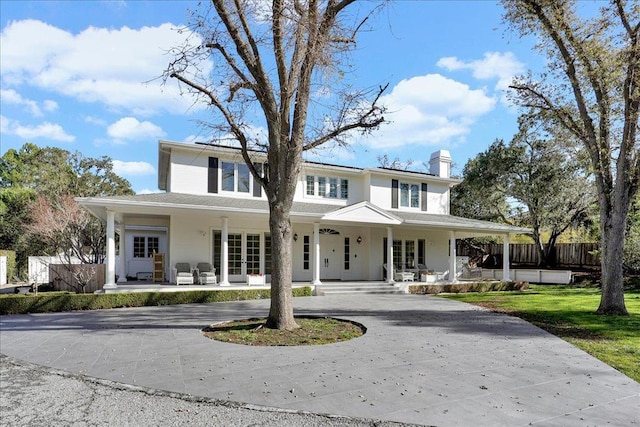 farmhouse-style home with covered porch and french doors