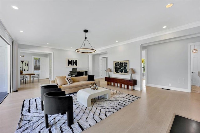 living room with ornamental molding, a wealth of natural light, and light wood-type flooring