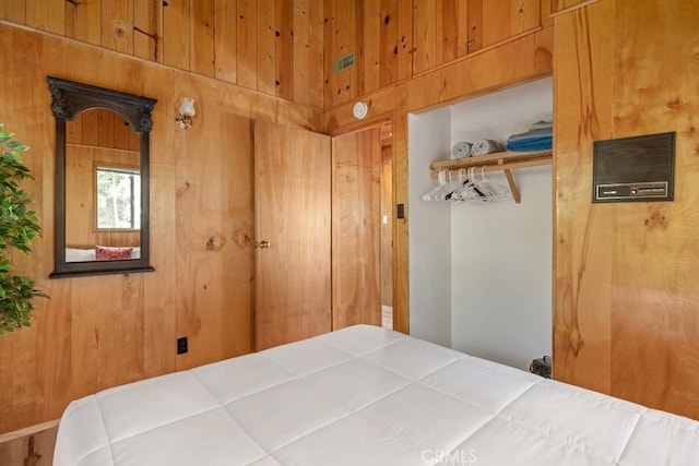 bedroom featuring wood walls