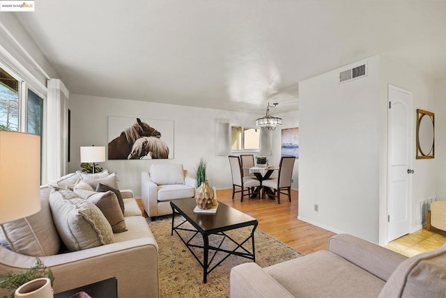 living room featuring an inviting chandelier and light wood-type flooring