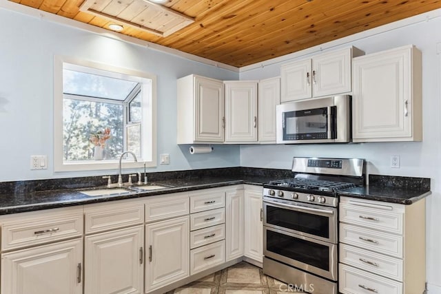 kitchen with white cabinetry, sink, dark stone countertops, wood ceiling, and stainless steel appliances