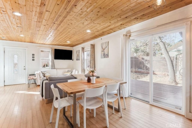 dining space with a wealth of natural light, wood ceiling, and light hardwood / wood-style flooring