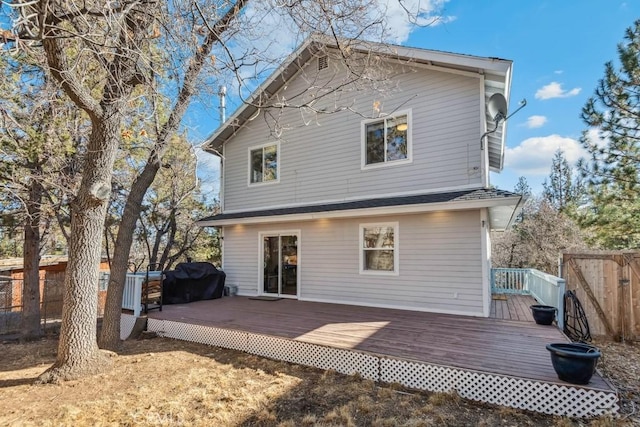 rear view of property featuring a wooden deck