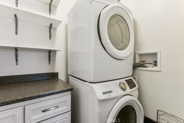 clothes washing area with stacked washer and clothes dryer