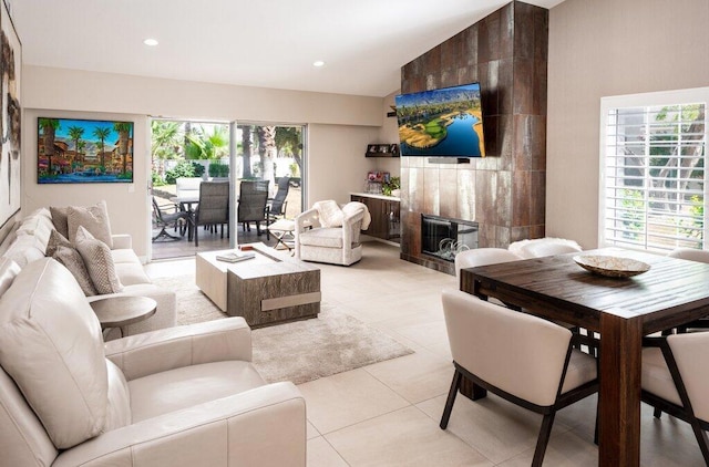 tiled living room with a tiled fireplace and lofted ceiling