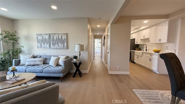 living room featuring sink and light hardwood / wood-style floors