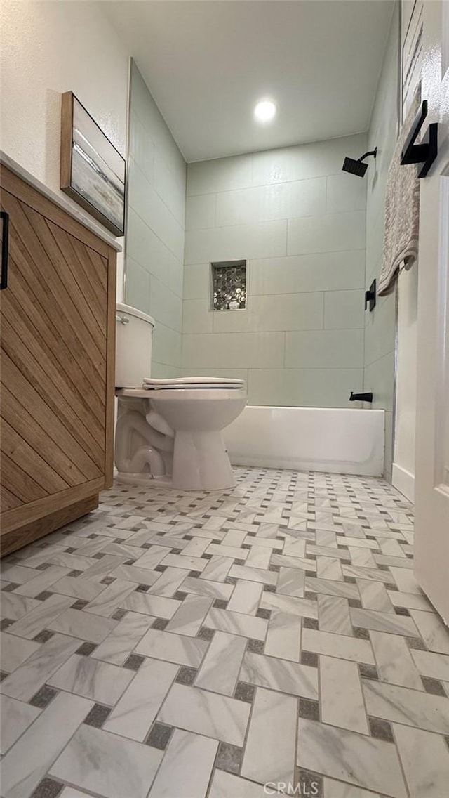 bathroom with tiled shower / bath and toilet