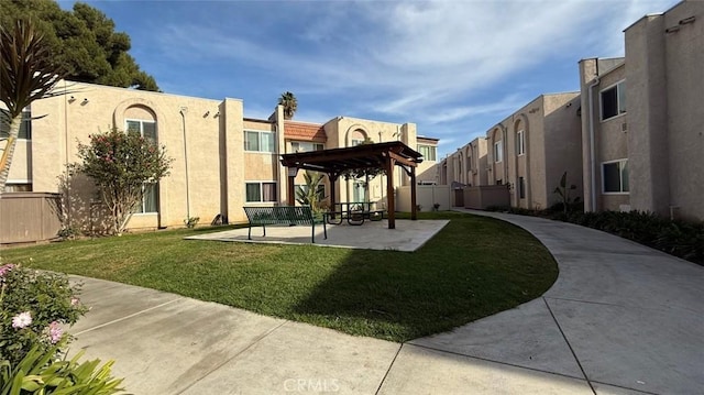 view of property's community with a pergola and a lawn