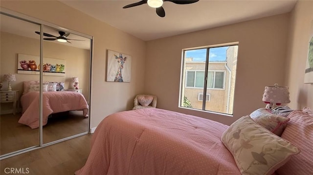 bedroom with ceiling fan, wood-type flooring, and a closet