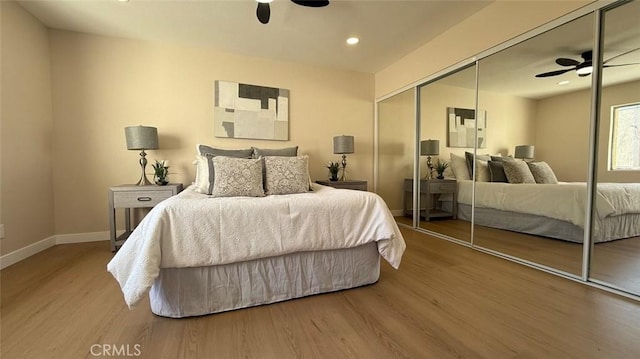 bedroom with hardwood / wood-style flooring, a closet, and ceiling fan