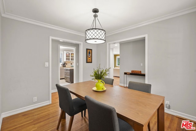 dining space featuring wood-type flooring and ornamental molding