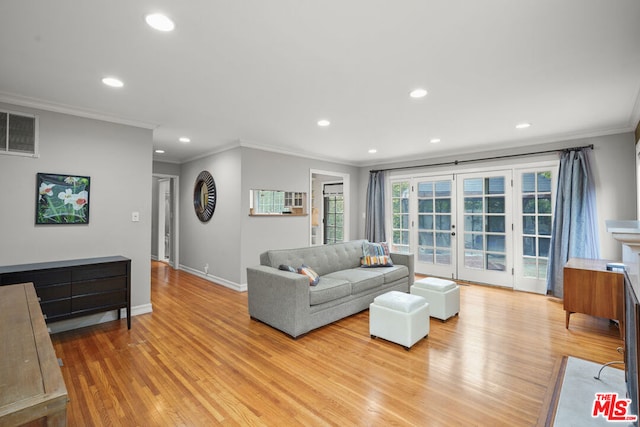 living room featuring crown molding, french doors, and light wood-type flooring